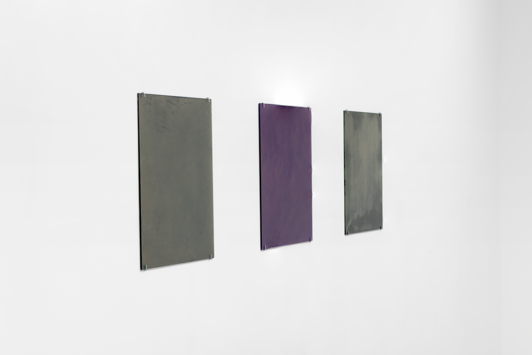 3 small glass paintings on a white wall.